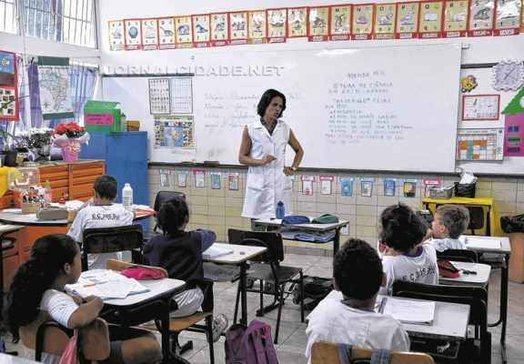 Professor enquanto ministra aula a alunos em escola pública. A remuneração dos docentes brasileiros é uma das mais baixas do mundo (foto Agência Brasil)