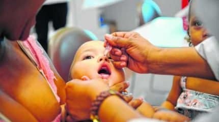 Criança toma vacina contra a paralisia infantil (poliomielite) em unidade de saúde (foto Agência Brasil)