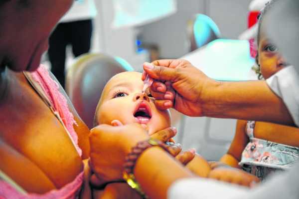 Criança toma vacina contra a paralisia infantil (poliomielite) em unidade de saúde (foto Agência Brasil)