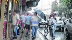 Os consumidores caminhavam sob chuva na Rua 4 na tarde dessa terça-feira (23). As lojas abrem hoje das 9 às 18 horas