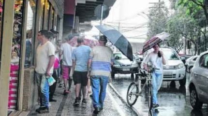 Os consumidores caminhavam sob chuva na Rua 4 na tarde dessa terça-feira (23). As lojas abrem hoje das 9 às 18 horas