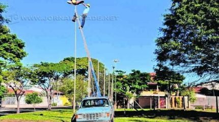 A equipe de manutenção da prefeitura realiza trabalho para funcionamento de luminárias de praça em bairro da cidade