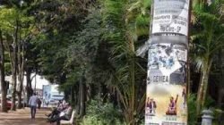 Postes de iluminação pública com vários cartazes no cruzamento da Rua 4 com a Avenida 2