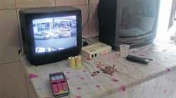Dezoito máquinas foram apreendidas no total. Na mesa da cozinha, uma televisão mostrava imagens do movimento da rua