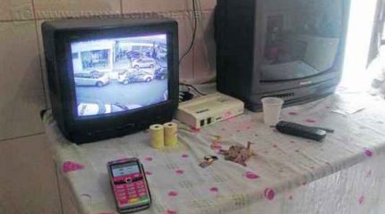 Dezoito máquinas foram apreendidas no total. Na mesa da cozinha, uma televisão mostrava imagens do movimento da rua