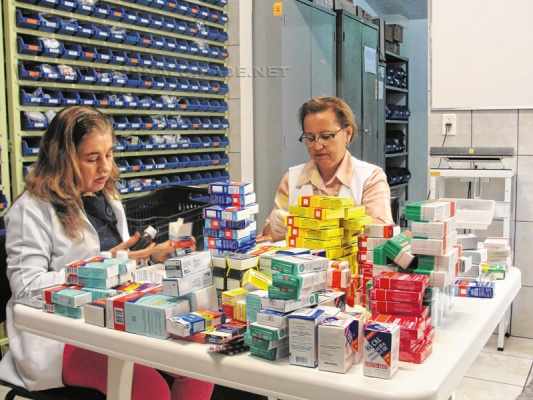Voluntárias realizam a triagem dos medicamentos recebidos na farmácia do Abrigo; validade e condições são verificadas