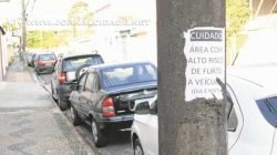 “Cuidado: área com alto risco de furto a veículos (dia e noite)” - diz o cartaz no poste