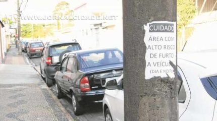 “Cuidado: área com alto risco de furto a veículos (dia e noite)” - diz o cartaz no poste