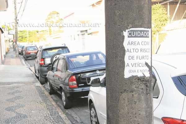 “Cuidado: área com alto risco de furto a veículos (dia e noite)” - diz o cartaz no poste