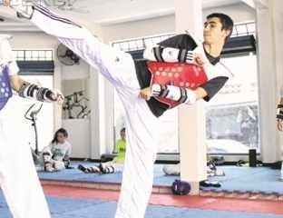 O atleta Guilherme Dias (à direita) durante treino na academia da equipe Carmen Carolina Pro Team de Taekwondo
