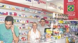 Denis Camargo, Cida e Paulo Cézar Carvalho Martinez no balcão da farmácia. Proprietária do estabelecimento fala sobre o fim do programa Farmácia Popular
