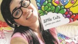 A artista Joana Diggle segura um exemplar do seu livro ‘Little Cats’- Gatinhos Para Colorir
