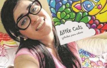 A artista Joana Diggle segura um exemplar do seu livro ‘Little Cats’- Gatinhos Para Colorir