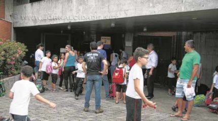 Alunos e pais no portão de entrada da unidade do Sesi local na Avenida M-29, no Jardim Floridiana. Ensino integral será reduzido pela instituição