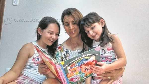 Edilene lê para suas filhas, Eduarda de 9 anos e Bruna de seis; as pequenas adoram livros