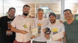 Camilo Cazonatto recebendo a premiação das mãos dos organizadores do concurso