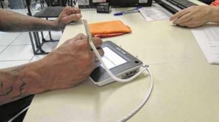 Eleitor faz assinatura digital durante atendimento para o cadastramento biométrico
