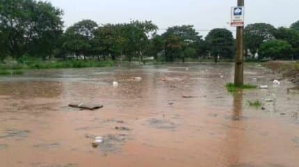 Avenida 16 alagada no Jardim São Paulo. No local, há uma placa que alerta sobre alagamentos