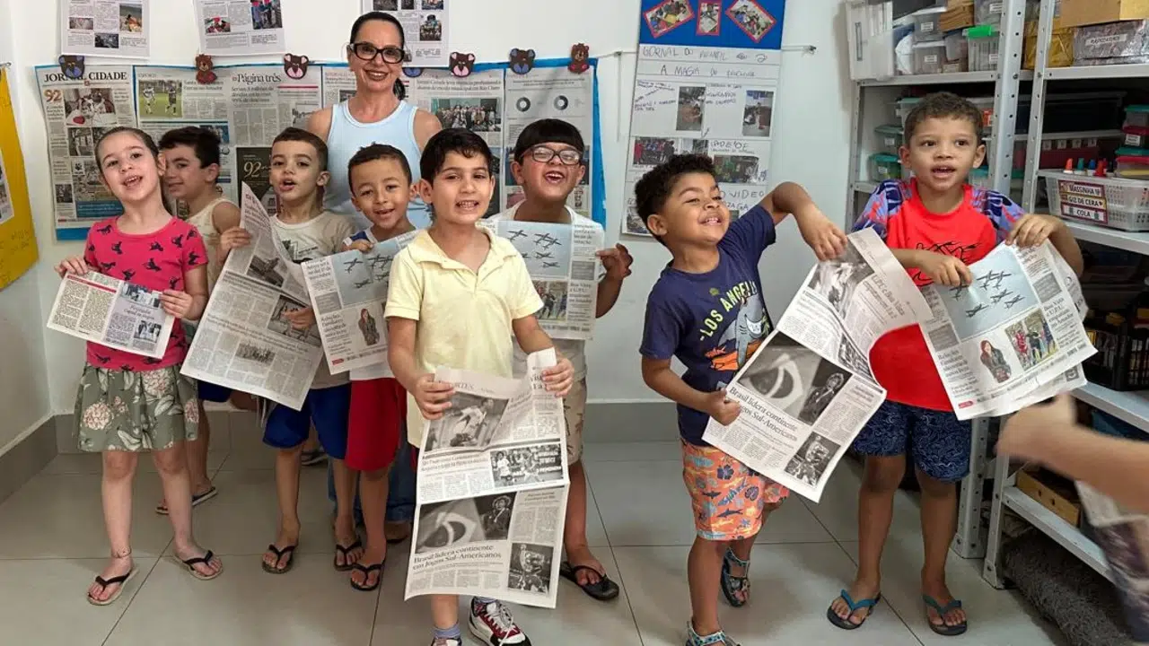 Crianças do Infantil II, ao lado da professora Rosângela Penteado mostrando o jornal produzido por eles, durante visita do Jornal Cidade